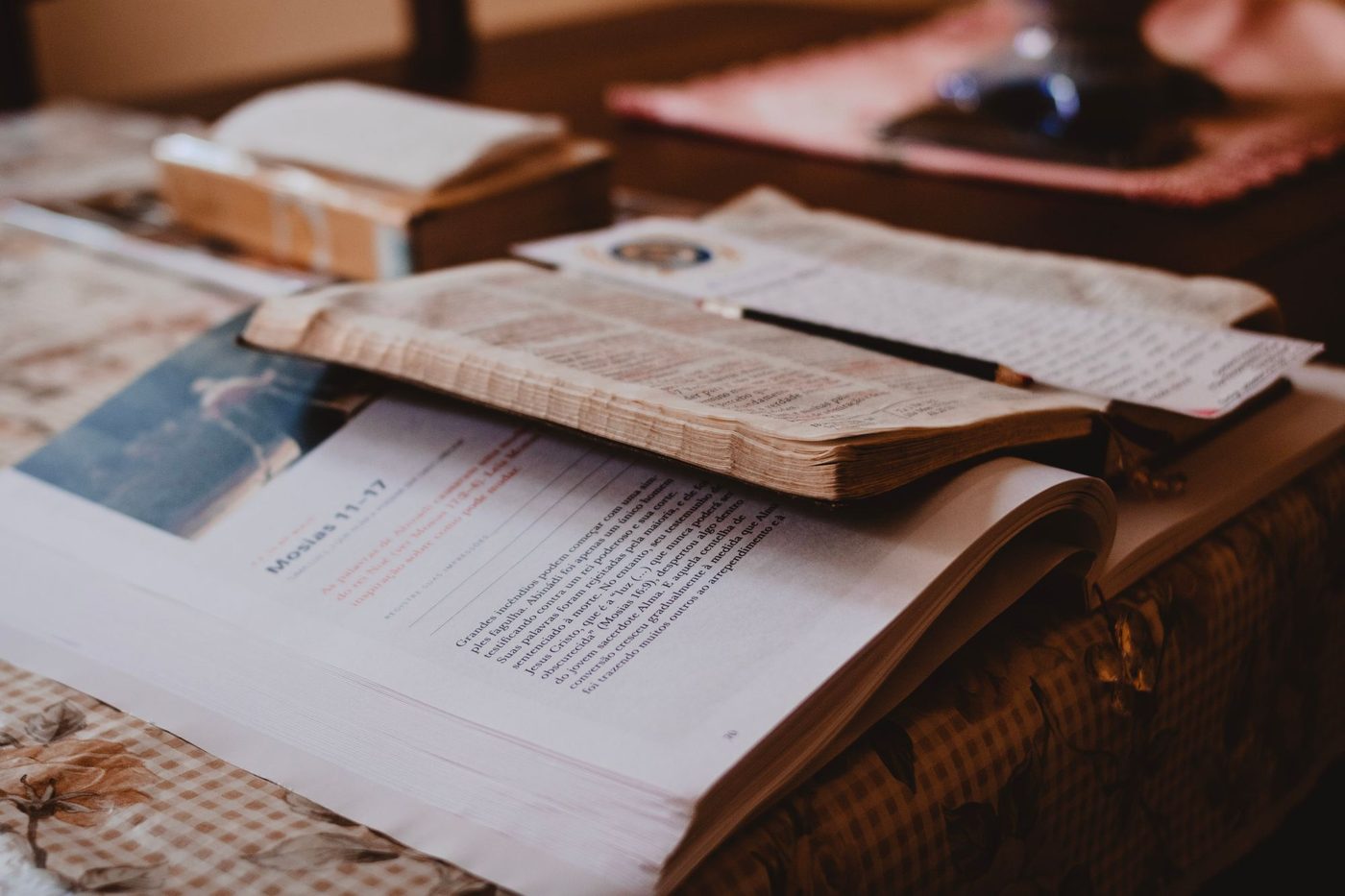 An open Bible beside a notebook and study notes on a table