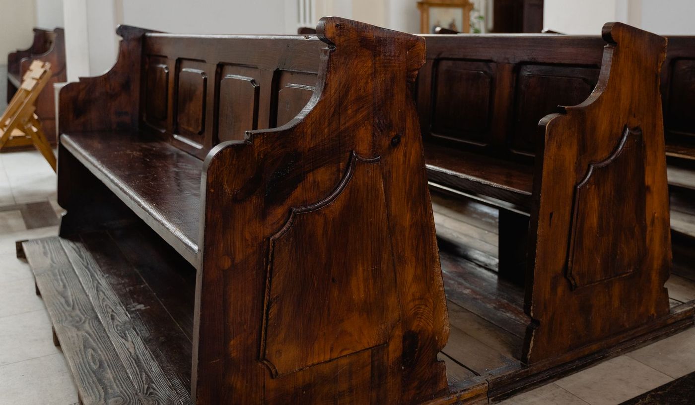 Empty wooden pews in a quiet church sanctuary